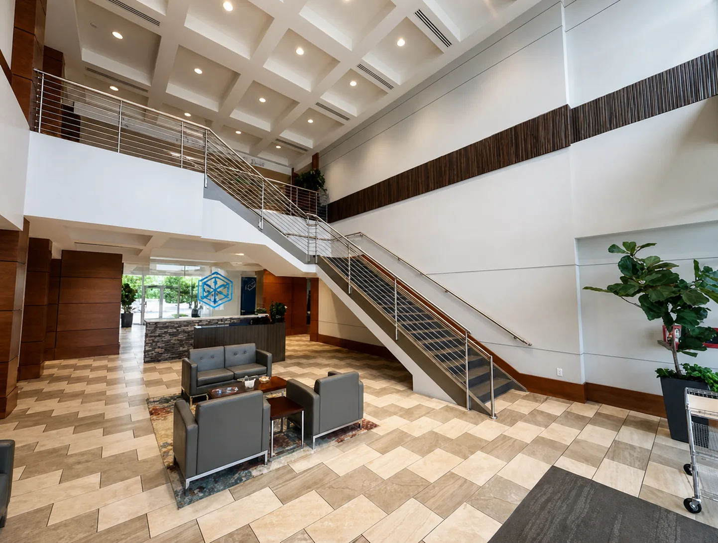 Two-story shared lobby with grand staircase and coffered ceiling